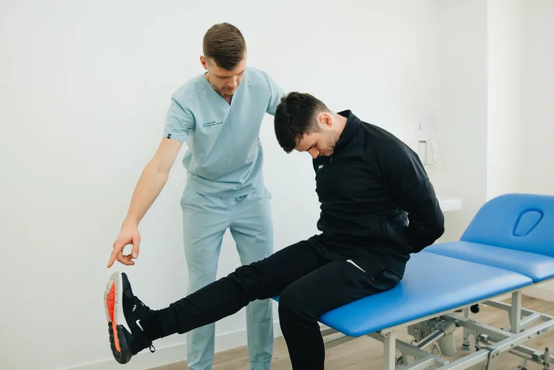 Patient accompagné dans un mouvement par un professionnel de rééducation