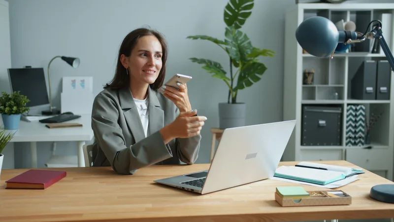 Professionnelle utilisant son téléphone à son bureau