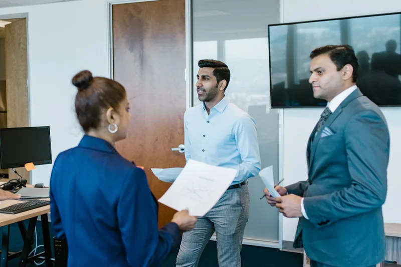 Professionnels discutant devant un écran dans une salle de réunion