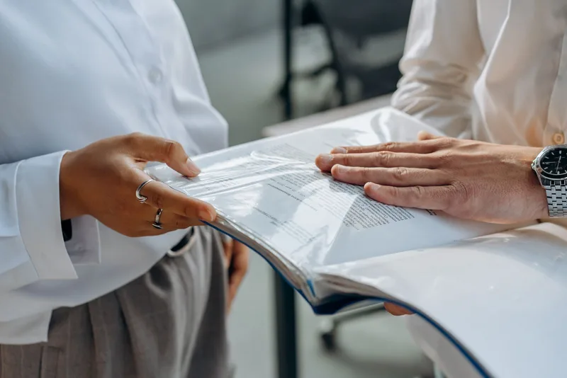 Deux personnes examinant ensemble un document posé sur une table